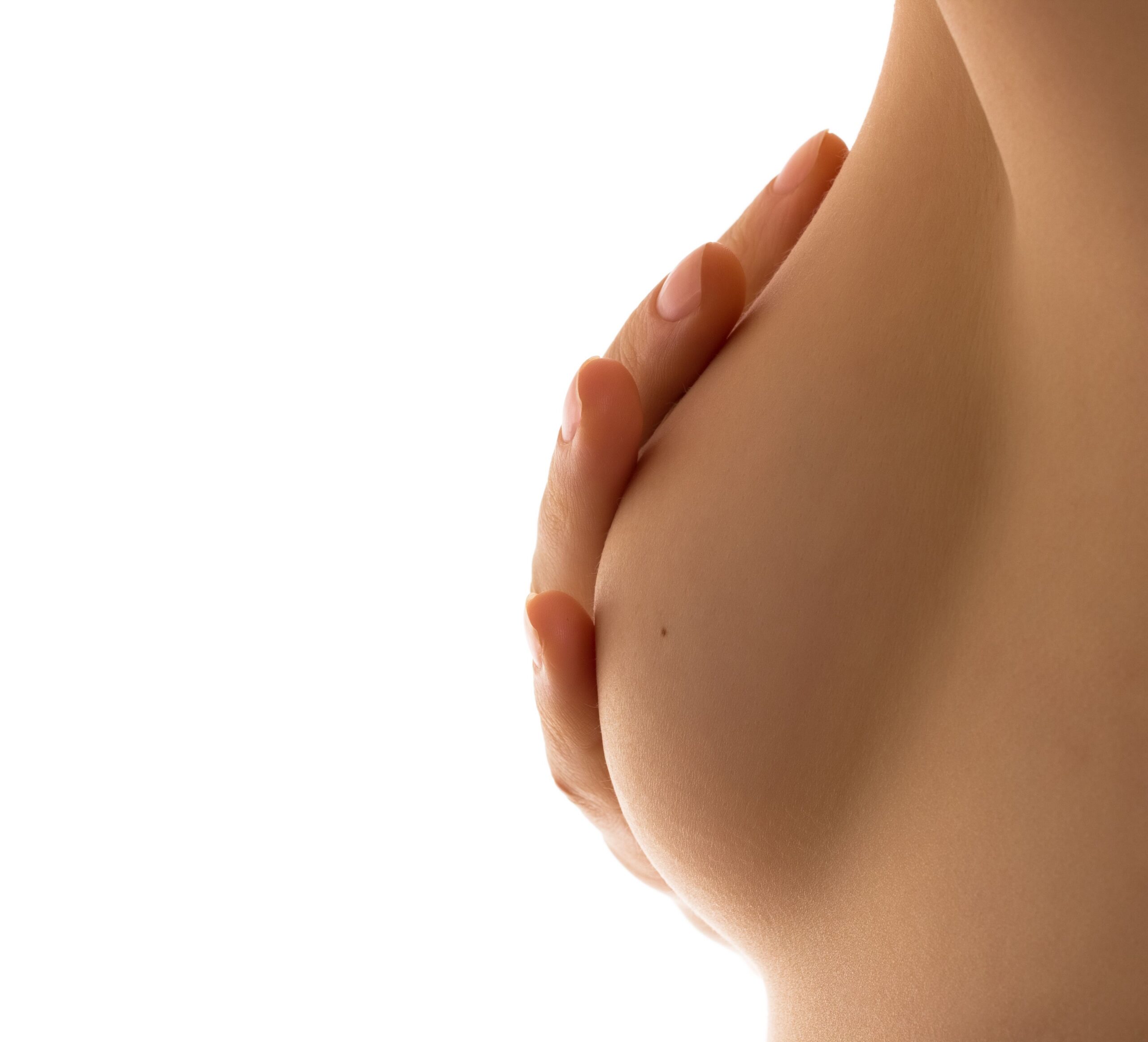 Close-up of a woman’s hand over her breast, concealing her areola